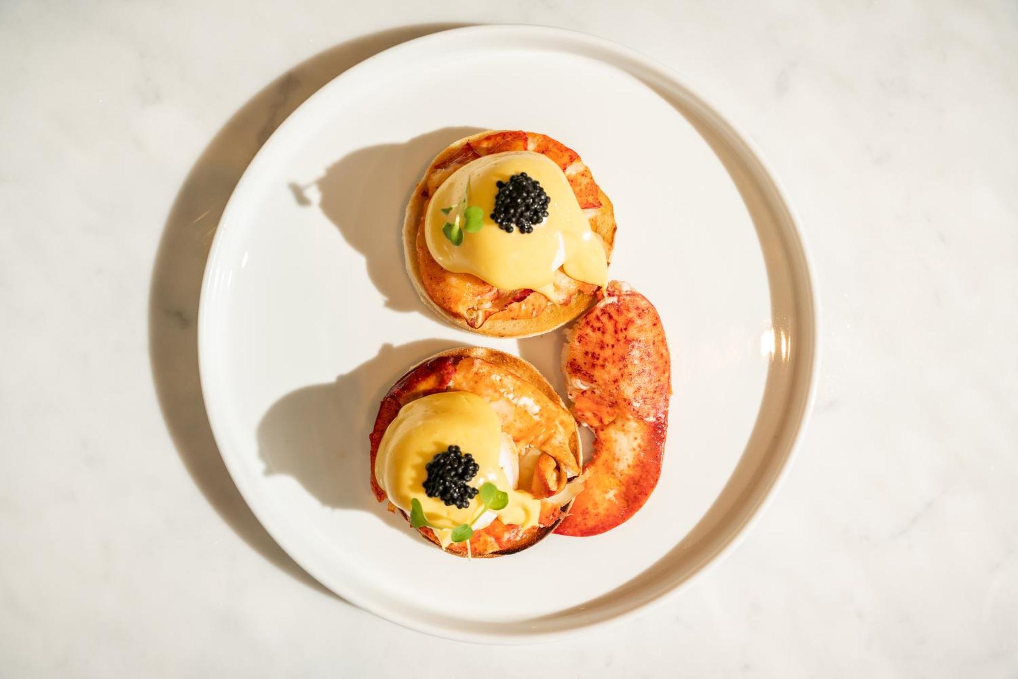 โรงแรมเซนต์ มาร์ติน เลน ลอนดอน ภายนอก รูปภาพ The photo shows a plate with two servings of a dish that appears to be eggs Benedict. Each serving consists of a toasted English muffin topped with poached eggs, creamy hollandaise sauce, and garnished with black caviar and possibly some green onions