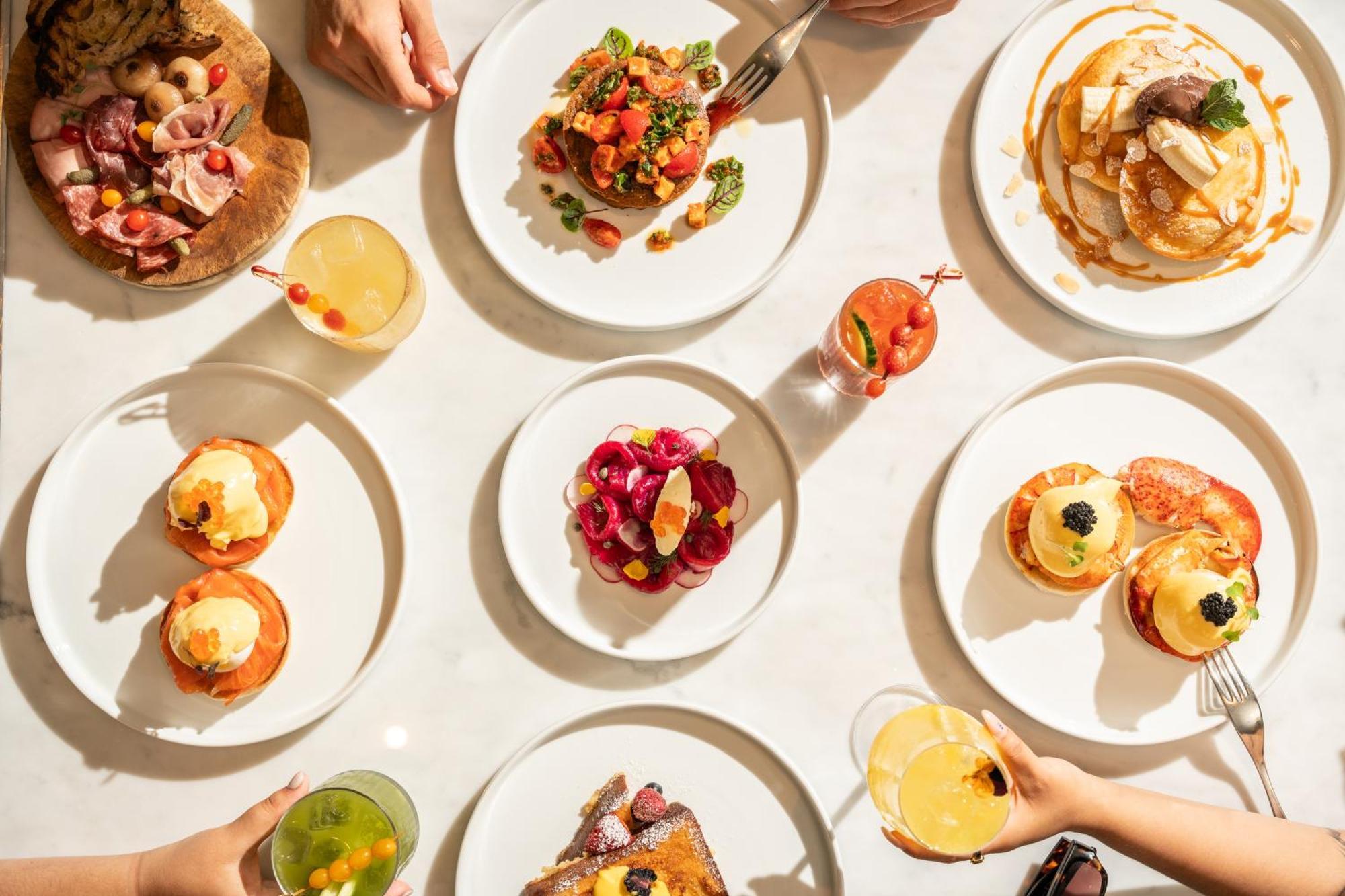 โรงแรมเซนต์ มาร์ติน เลน ลอนดอน ภายนอก รูปภาพ The photo showcases a vibrant spread of food arranged on a table. There are several white plates displaying a variety of dishes. 

1. **Savory Dishes**: One plate features a colorful salad with tomatoes and greens. Another looks like a decadent dish,